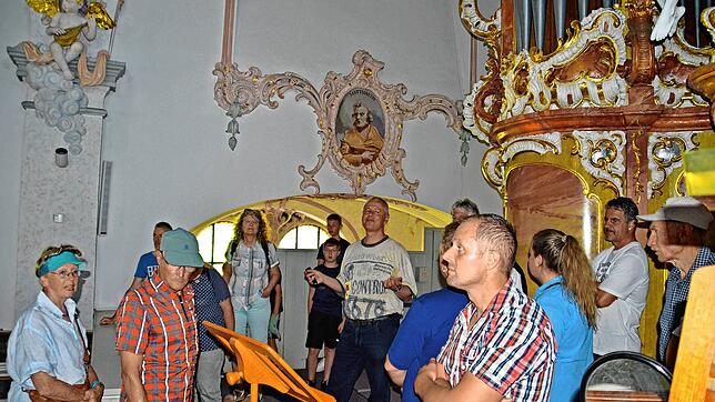 Jochen Schultheiß (Mitte) führt interessierte Besucher in den Kirchenraum und auf den Kirchturm der Pfarrkirche hinauf. Foto: Lisa Nagel
