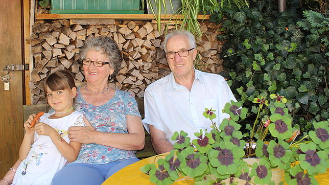 Vor dem Gartenhäuschen gibt es einen schattigen Sitzplatz. Gisela und Erwin Schmucker sitzen hier mit Enkelin Anna, die sich gerade aus ...