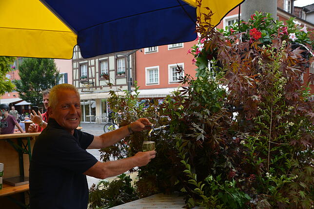 Alfred Strobel von der Freiwilligen Feuerwehr zapft den Wein aus dem Brunnen.