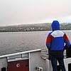 Nur wenige Menschen zieht es auf der Fähre von Konstanz nach Meersburg an die Reling, das Bodensee-Panorama ist von Nebelwolken umhüllt.