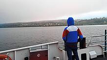 Nur wenige Menschen zieht es auf der Fähre von Konstanz nach Meersburg an die Reling, das Bodensee-Panorama ist von Nebelwolken umhüllt.
