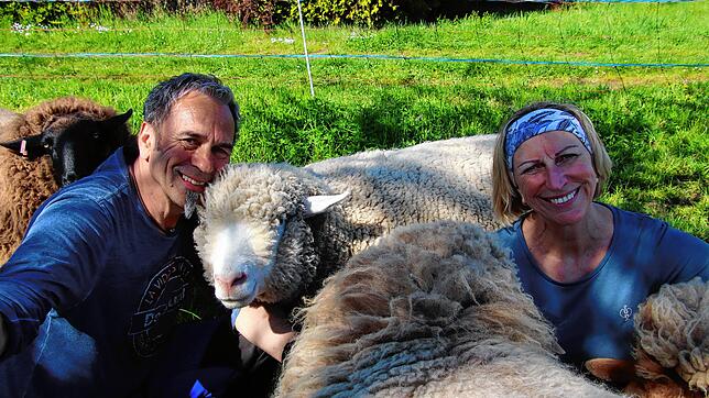 Hardy Buck und Barbara Stotz kuscheln mit ihren Schafen.