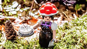 Die Playmobil-Sonderfigur „Schwarzwald Marie“ in klassischer Tracht, mit Schwarzwälder Kirschtorte und dem markanten roten Bollenhut.