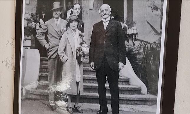 Mary Pickford und Douglas Fairbanks stehen auf einem Foto mit den ersten Eigentürmern, der Familie Luz, vor dem Hotel.