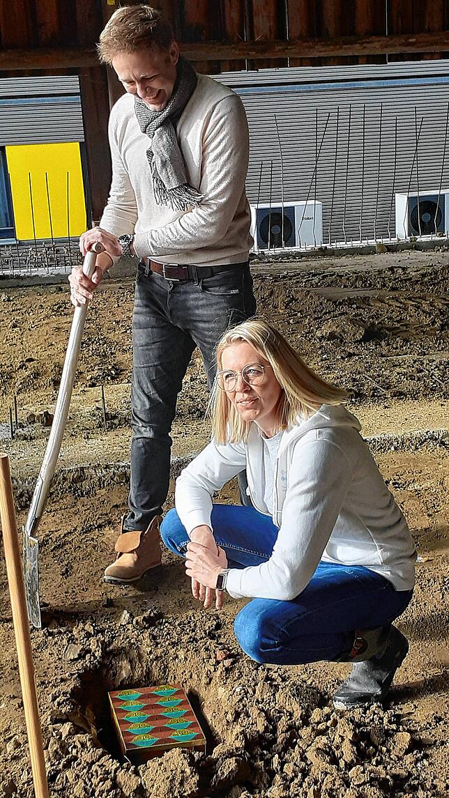 Melanie und Paul Lohmeyer versenken als Grundstein eine Blechkiste in den Baugrund des geplanten Threapiezentrums.