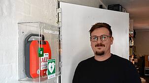 Marius Riether, betrieblicher Ersthelfer, neben dem neuen AED-Gerät im „atelier 522“.
