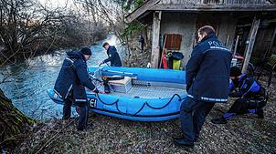 Einsatzkräfte der Polizei lassen ein Boot in das Gewässer der Lauchert ab. In dem Fluss ist die Zweijährige Mitte Dezember verunglückt.