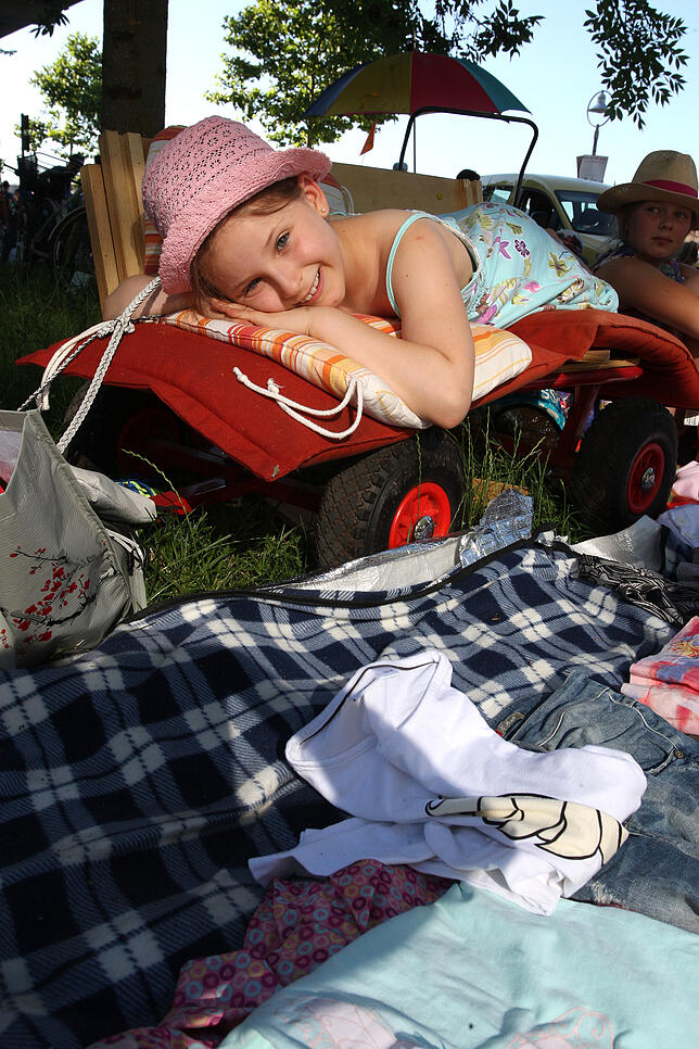 Gewusst wie: Die erfahrene Flohmarkt-Standbetreiberin Amelie Luisa Kasparek (8) hat sich ein luftiges Schattenplätzchen am Rhein gesucht ...