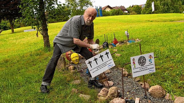 Salvatore Mainardi stellt an seiner Installation im Skulpturenpark Grafenhausen Schilder auf. Foto: Wilfried Dieckmann