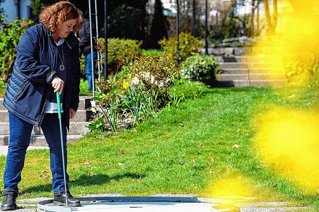 Britta Steib-Kreft macht vor, wie das mit dem Einlochen geht. Sonnenschein lockt an diesem Tag an den See.