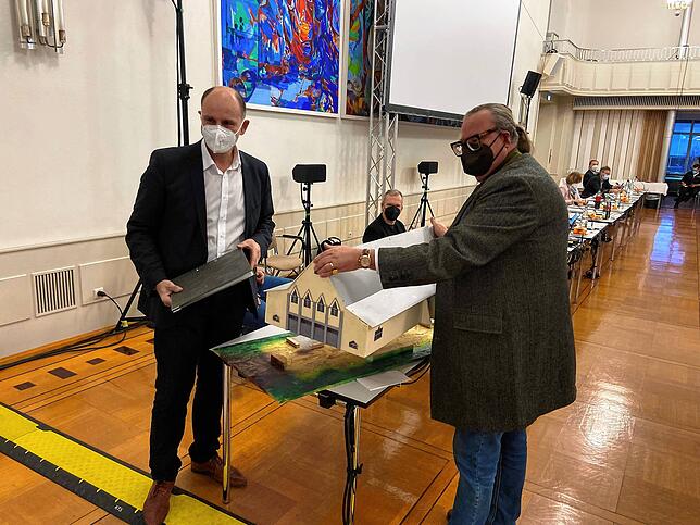 Peter Adrian Gäng (rechts) vom Förderverein Freunde der Scheffelhalle übergibt Singens Oberbürgermeister Bernd Häusler (links) ein ...