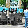 Blick nach Friedrichshafen am Wochenende: Stühle und Tische stehen aufgereiht an der Uferpromenade, während im Hintergrund Passanten ...