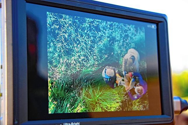 Die Helfer haben ein Rehkitz gefunden und bringen es sicher an den Rand der Wiese. Über den Monitor können die anderen Helfer das ...