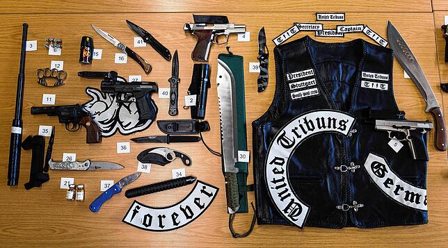Zahlreiche beschlagnahmte Waffen und eine Leder-Jacke liegen auf einem Tisch im Polizeipräsidium Stuttgart. Die Gegenstände hatte die ...