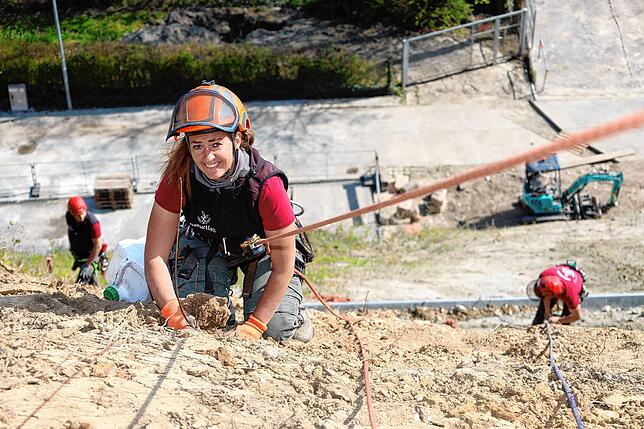 Projektkoordinatorin Sara Mauz pflanzt hier einen Feldahorn. Insgesamt werden am Hang oberhalb der Hoheneggstraße 120 junge Bäume gesetzt.