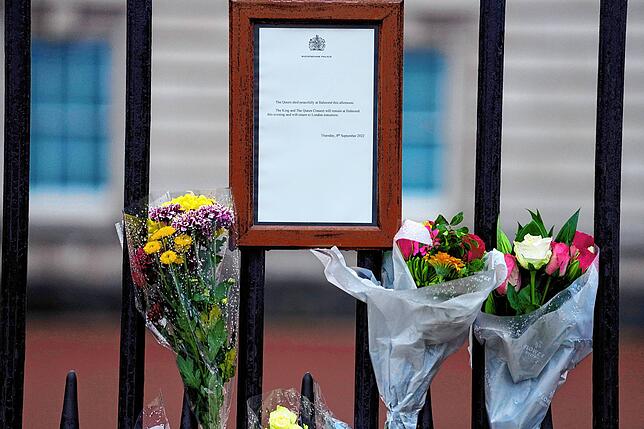 Blumen liegen neben der Nachricht des Buckingham Palastes, die den Tod von Königin Elizabeth ankündigt.