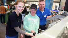 Girls’ Day bei ZF: Lilli Kubitzky und ihr Papa Sven lassen sich von der Auszubildenden Celine Danner die Arbeit an der Drehmaschine ...