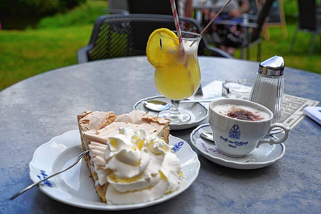 Eis und Kuchen im Café im Schloss werden draußen und drinnen serviert.