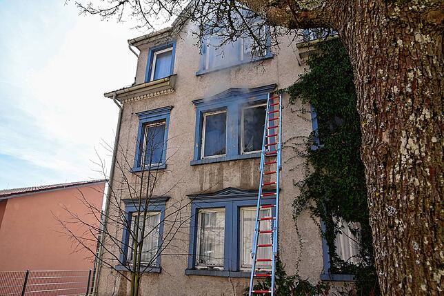 Rauchschwaden dringen aus dem Fenster, das die Feuerwehr zur Durchlüftung eingeschlagen hat.