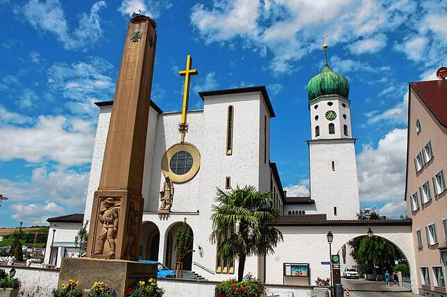 Die Kirche St. Oswald und ihr Vorplatz wurden erst kürzlich renoviert. Der Kirchturm ist weithin sichtbar. Links steht das ...