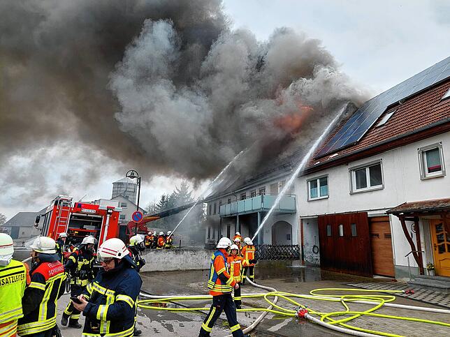 Die Feuerwehr versucht ein Übergreifen der Flammen auf das Nachbargebäude zu verhindern.
