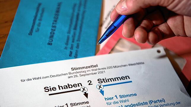 Briefwahlunterlagen für die Bundestagswahl 2021 mit Stimmzettel und Stimmzettelumschlag liegen auf einem Tisch.