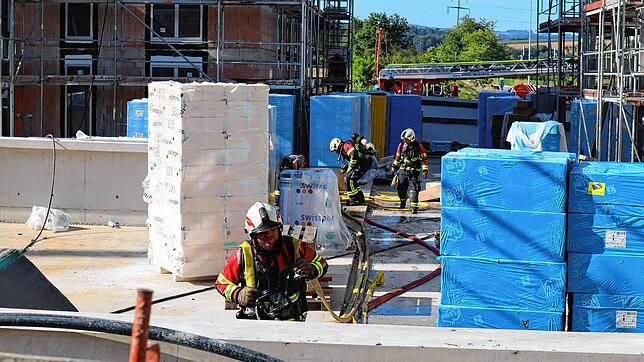 Fricker Feuerwehrleute räumen im Fricker Baugebiet Lammet zwischen Baumaterial ihre Löschschläuche weg. Auf dem Dach eines der Gebäude ...