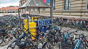 Fahrradflut im Juli 2025 auf der Marktstätte: Im Hintergrund ist die Ladenzeile (links oben) zu erkennen. An dieser Stelle ist ein ...