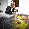 Michael Breuninger steht auf dem Balkon seiner Wohnung in Konstanz, wo Solarpaneelen angebracht sind. Foto: Felix Kästle/dpa