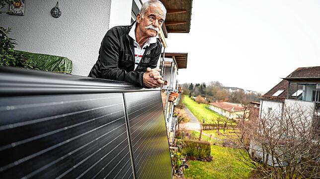 Michael Breuninger steht auf dem Balkon seiner Wohnung in Konstanz, wo Solarpaneelen angebracht sind. Foto: Felix Kästle/dpa