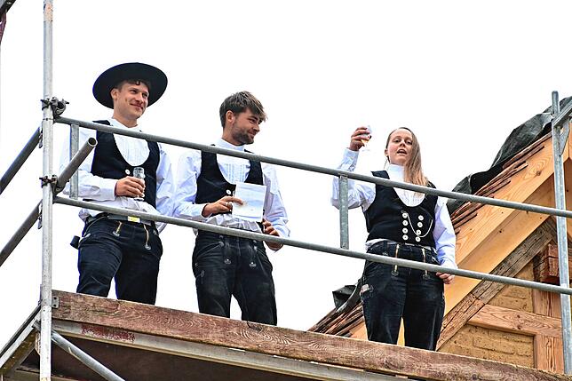 Steffen Wolf, Paul Konrad und Dorothee Steinbrich von der Firma Hummel halten den Richtspruch und werfen dann ihre Gläser an eine ...