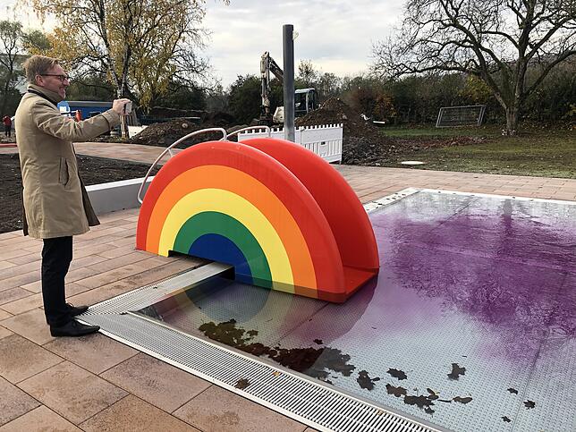 Oberbürgermeister Philipp Frank ist fasziniert vom Anblick des verfärbten Wassers. Er hält den Färbetest im Kinderbecken fotografisch ...