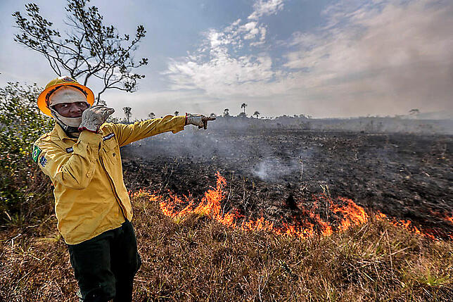 Waldbrände im Amazonas 26.08.2019, Brasilien, Manicoré: Anderson, Mitarbeiter des IBAMA, der brasilianischen Umweltbehörde, steht vor einem Brand in der Region ...