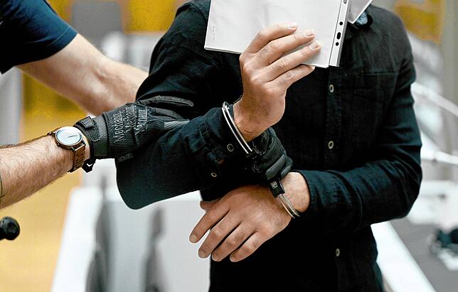 Die Angeklagten werden einzeln und in Handschellen in den Hochsicherheitssaal geführt.