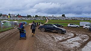 Die ersten Festivalbesucher reisen am Sonntagmorgen vom Southside 2024 ab. Für Autos ist der Weg durch den Schlamm nicht einfach.