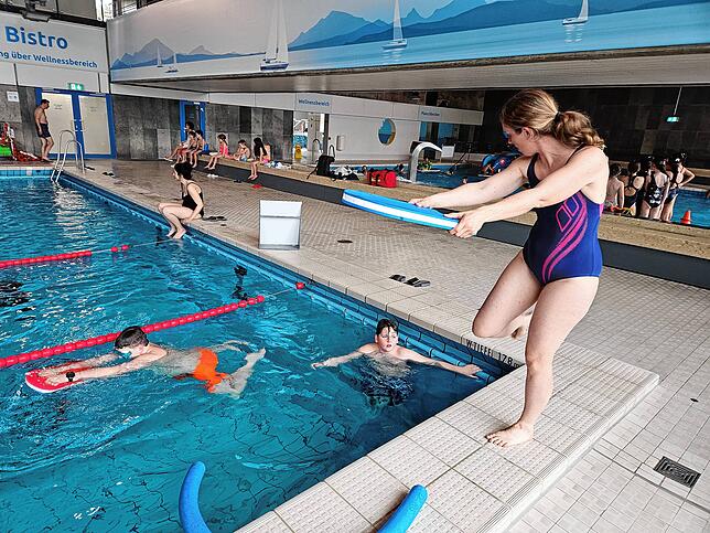 Schwimmlehrerin Katharina Seidel zeigt Schülern der Bickebergschule Übungen für den Rettungsschwimmer.