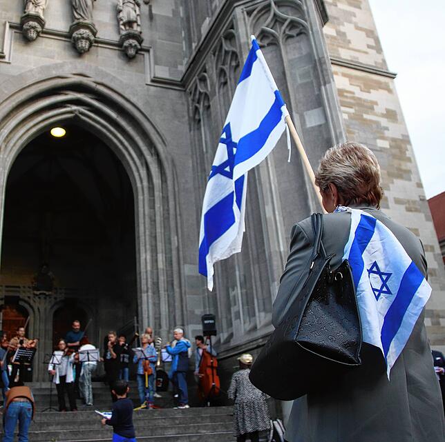 Eine Demonstrantin hielt bei der Solidaritätskundgebung für Israel auf dem Konstanzer Münsterplatz die israelische Flagge in die Luft. ...