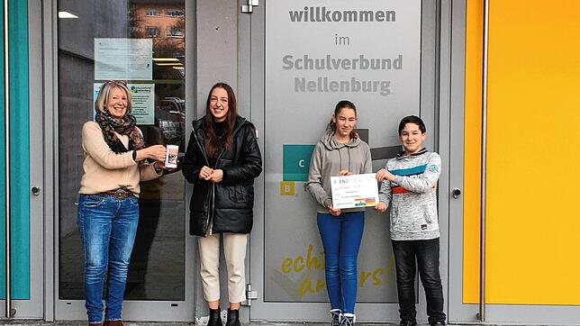 Lehrerin Ute Rauscher (v.l.) reicht Elisabeth Pohl die Spendenkasse, während Laura Maurer und Sebastian Moor den symbolischen Scheck halten.