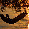 Eine Frau liest in einer Hängematte am Badestrand eines Campingplatzes in Lindau ein Buch. Viele Beschäftigte träumen davon, einmal für ...