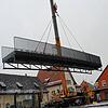 Wird mit einem Kran an Ort und Stelle gehoben: Die neue Fußgängerbrücke über die Aach.