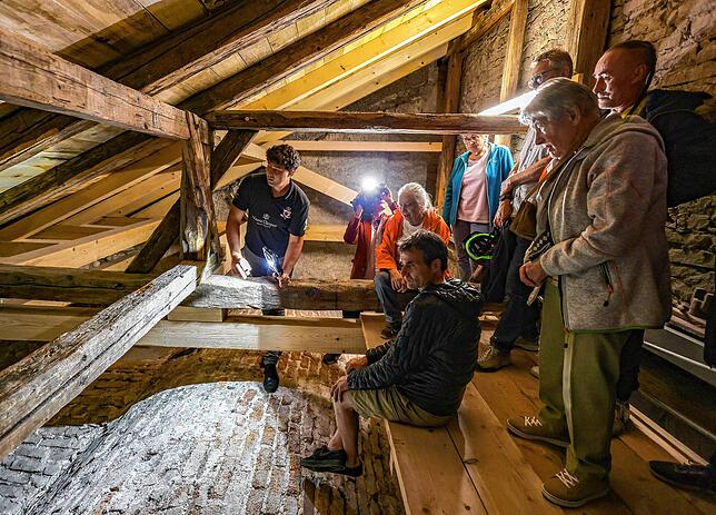 Blick in die verbesserte Dachkonstruktion des Münsters auf der Südseite des Gebäudes: Hier erklärt Zimmermann Nikolai Siegelin (links) ...
