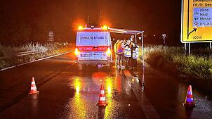 Einsatzkräfte stehen an einer abgesperrten Straße nach einem Unfall mit mehreren Toten. Drei Menschen sind infolge eines Unfalls bei ...