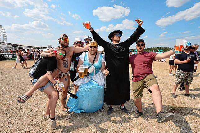 Einige Fans feiern ausgelassen mit unterschiedlichen Outfits.