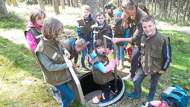 Einzeln klettern die Schüler der Vöhrenbacher Naturparkschule an einer Metallleiter einen 2,50 Meter tiefen Schacht hinunter und ...