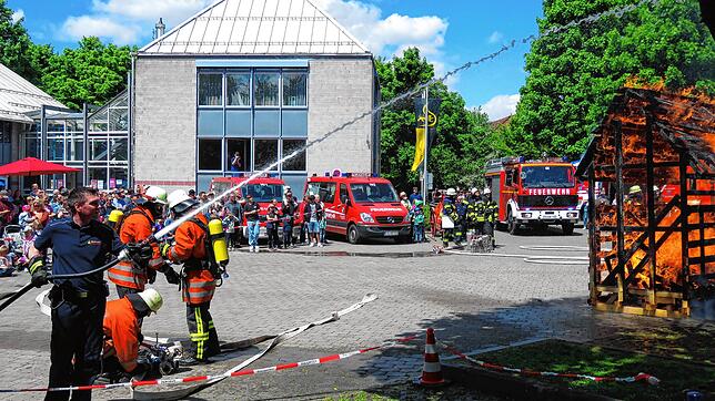 Feuerwehrmann Stephan Großmann (links) ist als erster vor Ort, um den Brand eines Holzschuppens per Löschangriff zu bekämpfen. Fotos: ...
