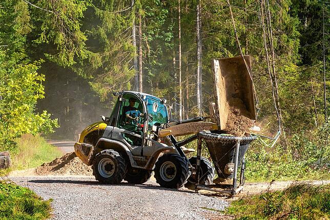 Waldbekalkung mit dem Helikopter. Rund eine Tonne Kalk füllt der Radlader in den Streubehälter unter dem Helikopter.