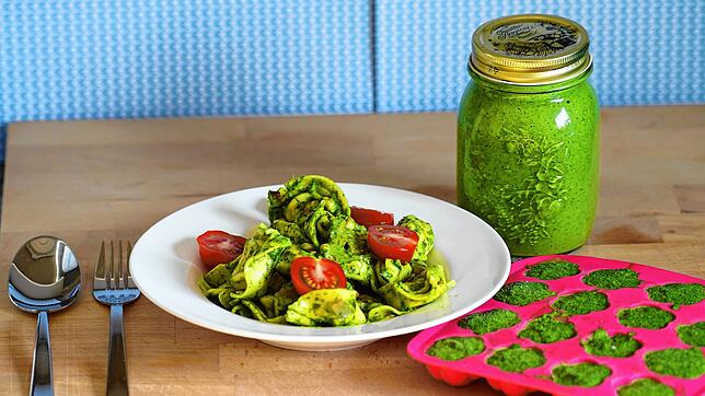 Frisch genießt man das Pesto am besten mit Pasta. Pienienkerne, Cocktailtomaten und Schinkenwürfel peppen die Teigwaren auf. Im Glas ist ...