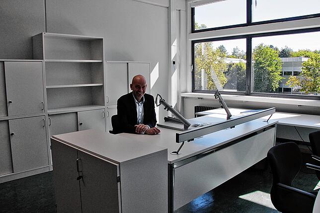 Schulleiter Zoran Josipovic sitzt schon einmal Probe an seinem neuen Arbeitsplatz mit neuen Möbeln im neuen Büro.