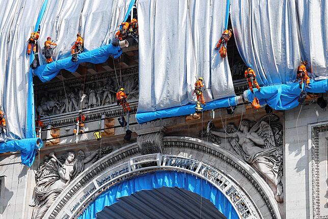 Die Stoffbahnen für die von Christo geplante Verhüllung des Triumphbogens wurden in Lübeck gefertigt. Gebäudekletterer bringen sie an.