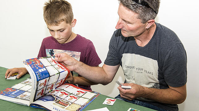 Maart Stöckle und Norbert Frank tauschen bei der Panini-Tauschbörse im Kunstverein Fußballbildchen aus.